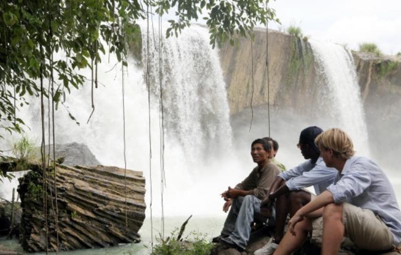 Du khách trải nghiệm đi bộ dưới chân thác Dray Nur, cảm nhận hơi nước mát lạnh và ngắm nhìn cảnh quan kỳ vĩ.